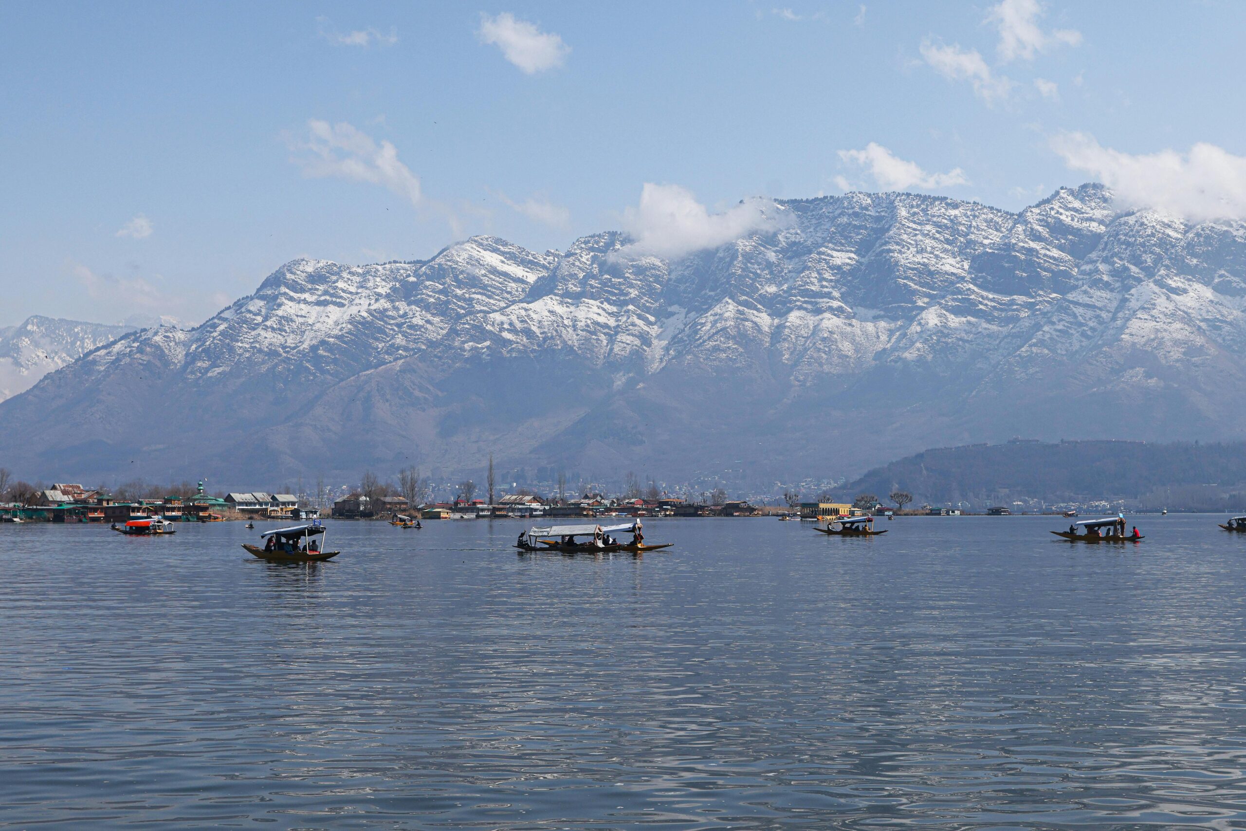 Shikaras on Dal Lake with the majestic Himalayas in the background.